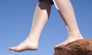 A pair of feet step off the edge into the void.
